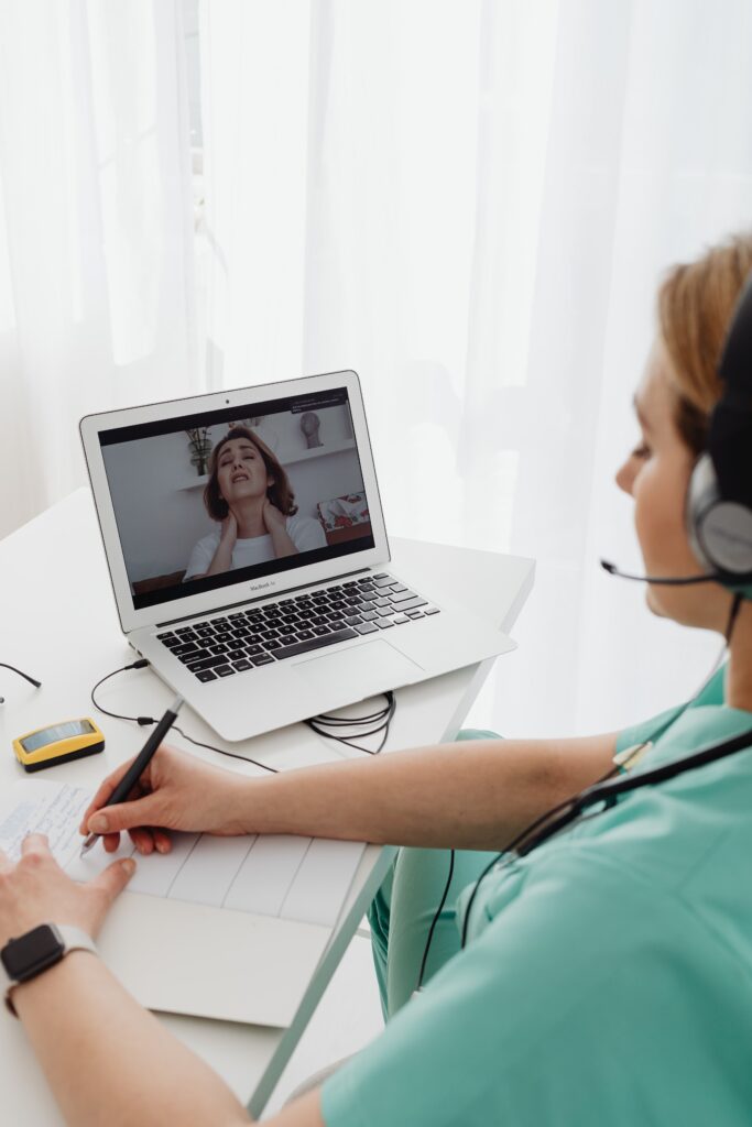 Virtual healthcare consultation between a doctor and patient using a laptop.